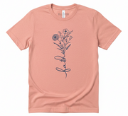 Pink t-shirt with floral design and 'faith' text on a white background