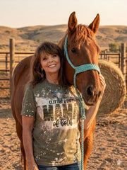 Woman standing next to a horse with a scenic background